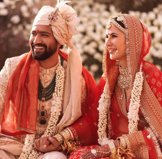 Katrina and Vicky seated side by side in red and ivory