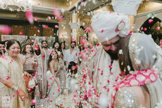 Family showering rose petals on the couple